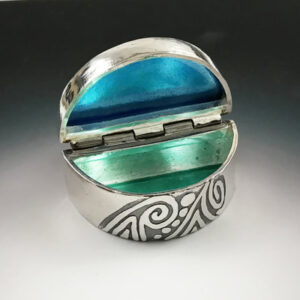 Open silver box with blue and green enamel inside